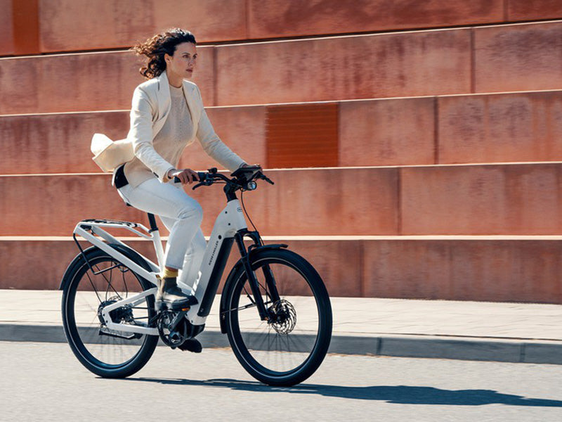 A woman riding a Homage electric bike by Riese and Muller.