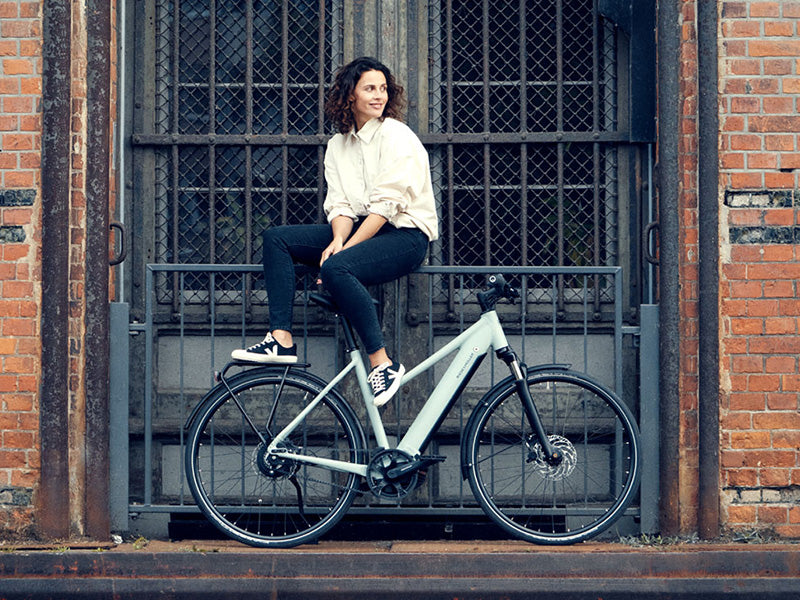 Woman sat by the side of her Roadster by Riese and Muller.Roadster by Riese and Muller